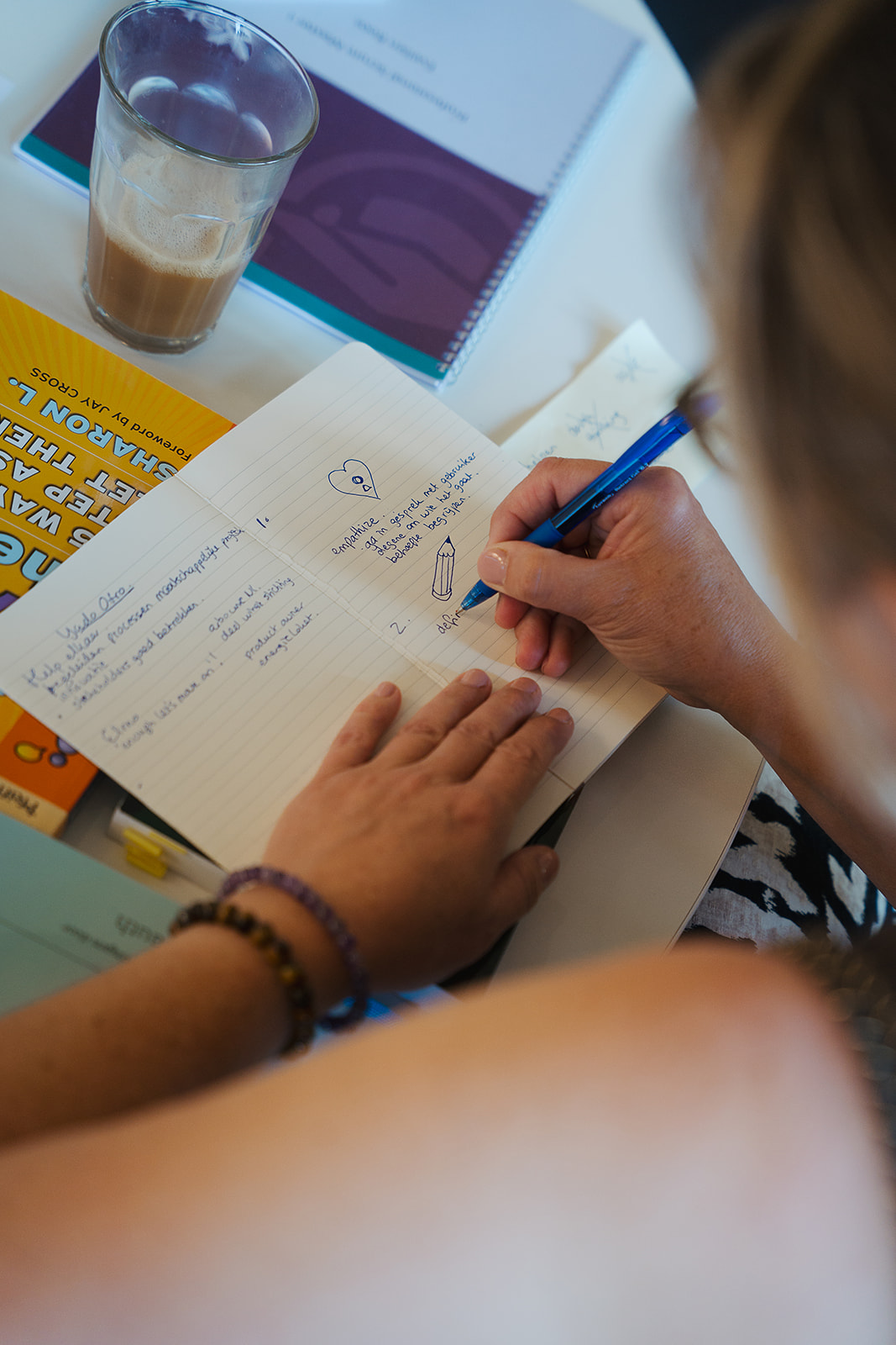 Een deelnemer schrijft tijdens een interactieve werkvorm.